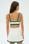 A woman wearing the SPLITS59 Monah Rigor Bra in White/Arugula stands with her back turned against a plain backdrop.