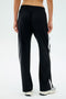 Someone wearing SPLITS59's Maxie Rigor Track Pant - Black/White is standing with their back to the camera.