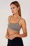 A woman wearing a Splits59 Loren Seamless Bra - Heather Grey and black leggings.