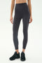 Person wearing SPLITS59 Airweight Super High Waist 7/8 leggings in Graphite, made from soft Airweight fabric with black athletic shoes, standing against a white background—ideal for hot yoga sessions.
