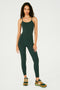 Full front view of girl wearing dark green one piece with leggings and spaghetti straps with multi colored shoes