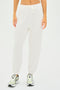 Individual wearing SPLITS59 Andie Oversized Fleece Sweatpant in white and silver sneakers against a plain backdrop.