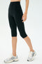 A person wearing SPLITS59 Airweight High Waist 16" Leggings in black and white running shoes stands against a plain light background.