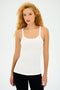 A person with curly hair is wearing the SPLITS59 Charlie Rib Tank in white, paired with black pants, against a plain background.