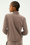 Seen from the back, a person with braided hair is wearing a taupe Max Rigor Track Jacket in Lentil/Black by SPLITS59, paired with matching Max Rigor Track Pants, set against a plain background.