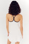Rear view of a woman with curly hair wearing a SPLITS59 Simona Airweight Tank Dress - White/Indigo with a black spandex strap design.