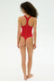 A person with curly hair, barefoot and facing away against a plain light background, wears the SPLITS59 Suki Airweight Bodysuit in Pirate Red.