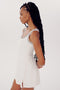 A person with long braided hair wearing a white sleeveless Martina Rigor Dress w/Piping - White from SPLITS59 stands against a plain white background, looking to the side.