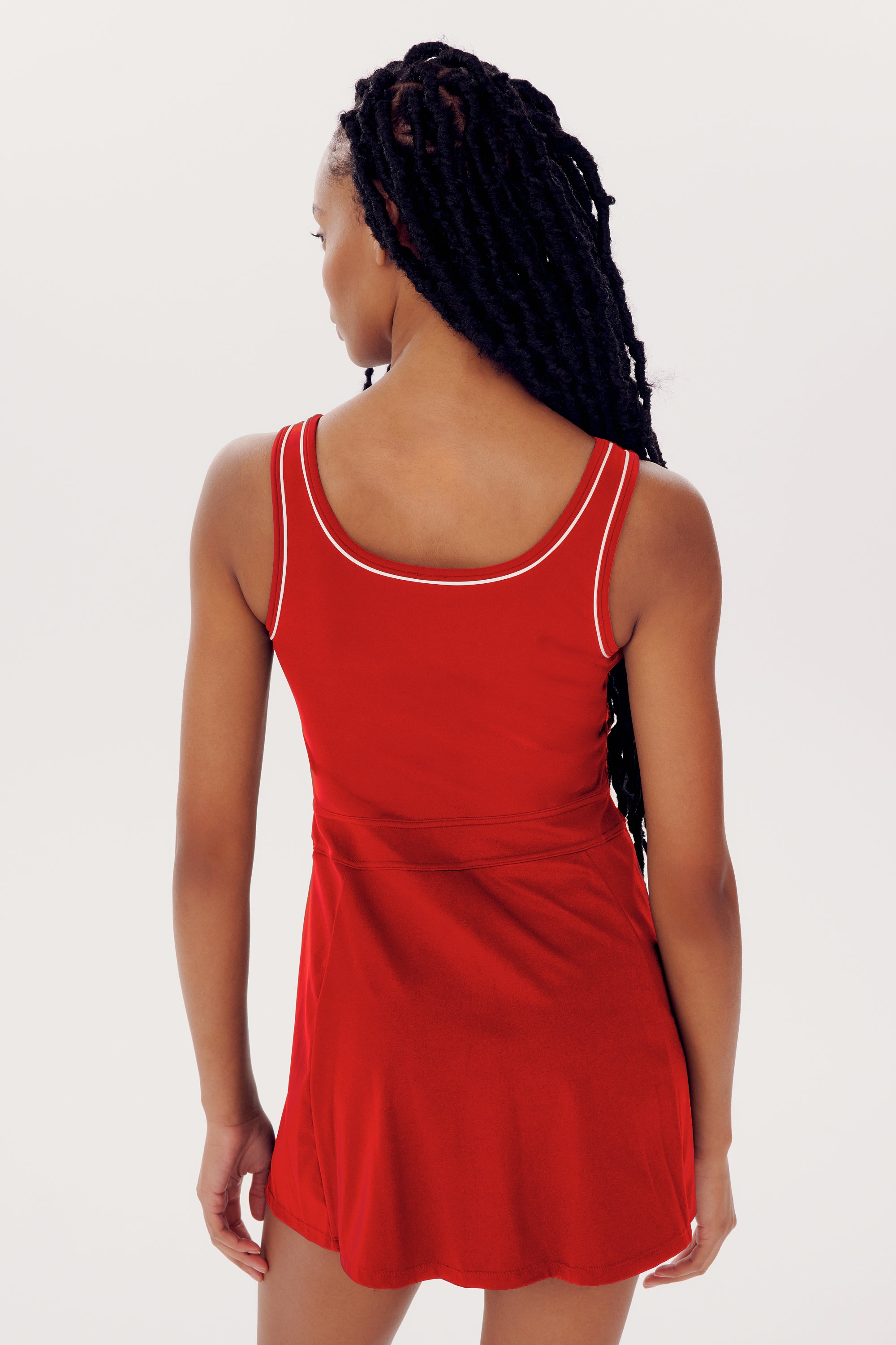 A woman with long braided hair wearing a sleeveless SPLITS59 Martina Rigor Dress w/Piping - Pirate Red is shown from the back against a plain white background.