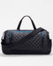 The SPLITS59 MZW x Splits59 Duffle is a black quilted bag with blue zippers, dual handles, an adjustable shoulder strap, and several exterior pockets, shown on a plain background.