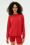 A woman with curly hair wears the SPLITS59 Andie Fleece Sweatshirt in Pirate Red, along with matching shorts, made from stretch modal fabric. She stands against a plain white background. Made in Los Angeles.