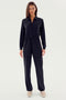 A person wearing a stylish SPLITS59 Ollie Airweight Boiler Suit - Black with beige shoes stands against a plain white backdrop, showcasing a sleek modern style.