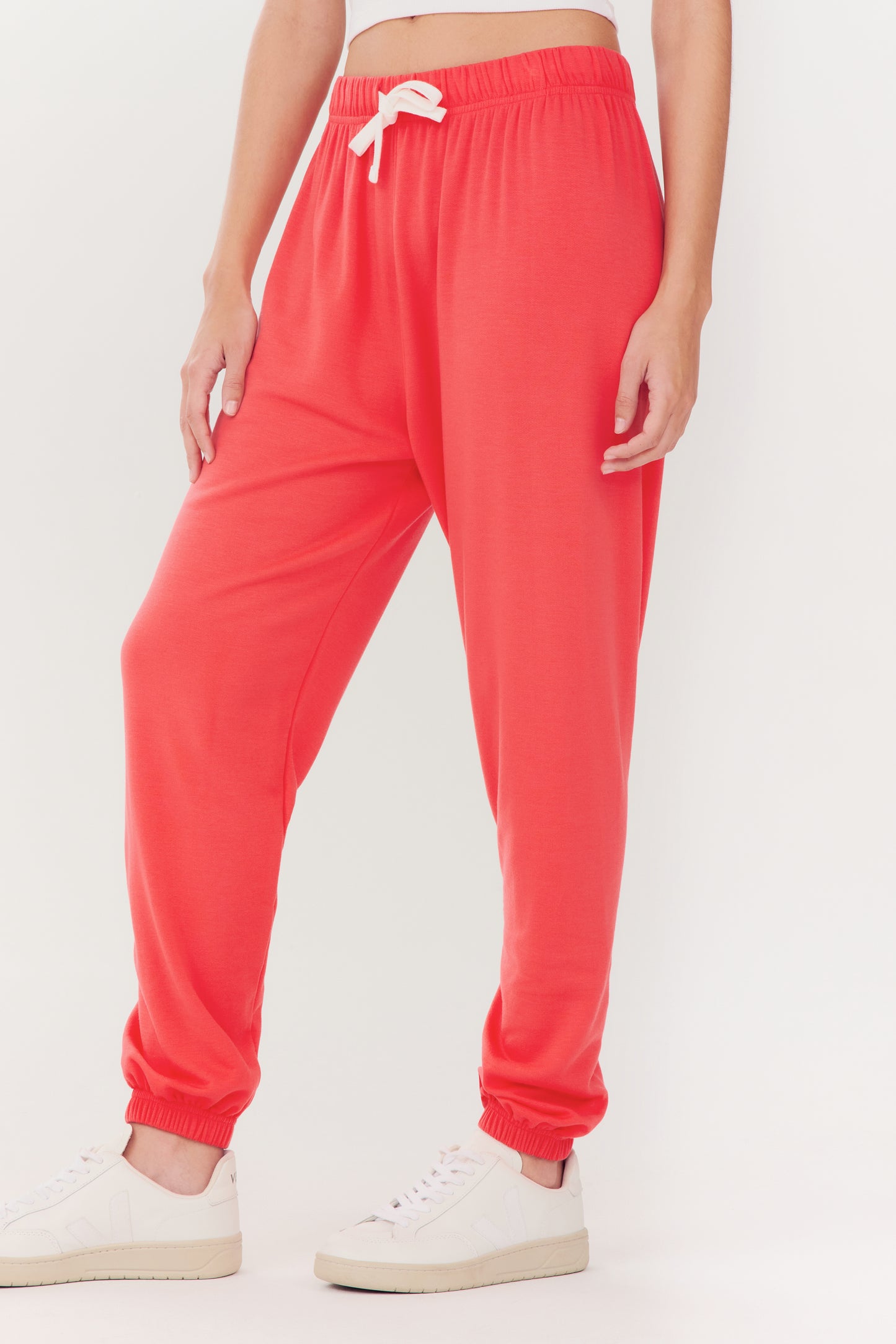 Person wearing Andie Oversized Fleece Sweatpant - Melon by SPLITS59 and white sneakers.