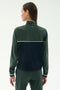A woman with straight brown hair wears the SPLITS59 Millie Airweight Half Zip in Military/Indigo, standing with her back to the camera against a plain background.