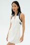 A woman wears the SPLITS59 Austin Rigor Dress in white/indigo, featuring a sleeveless design, zip-up front, and navy blue collar, standing against a plain light background.