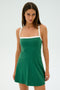 A person in the Monah Rigor Dress - Arugula/White by SPLITS59 stands against a white background, looking at the camera.
