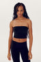A person with long braided hair is wearing a black SPLITS59 Hazel Airweight Crop Bandeau - Black and black spandex pants, standing against a plain white background.