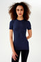A woman wearing a SPLITS59 Louise Rib Short Sleeve - Indigo t-shirt and black leggings, ready for yoga.