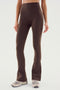 Person wearing SPLITS59 Raquel High Waist Flared Legging in Dark Chocolate with beige sneakers, standing against a plain background.