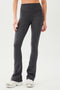 Front view of woman wearing dark gray high waist below ankle length legging with wide flared bottoms. Paired with white shoes.