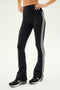 A person wearing the Raquel High Waist Flared Legging in Black/White by SPLITS59 with black sneakers stands against a plain background.