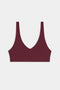 The SPLITS59 Airweight Scoop Back Bra, shown in burgundy with a deep V-neckline and wide shoulder straps, is displayed against a plain white background.