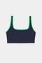 The SPLITS59 Cait Rigor Bra in Indigo/Grass features a square neckline, green trim, and high-performance Rigor fabric for supportive comfort—ideal for high-impact workouts. Shown on a white background.