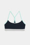 The SPLITS59 Emerson Airweight Bra in Indigo/Dove Grey features light blue straps, white trim, and a gray band—shown from the back on a white background—ideal for hot yoga or Pilates.