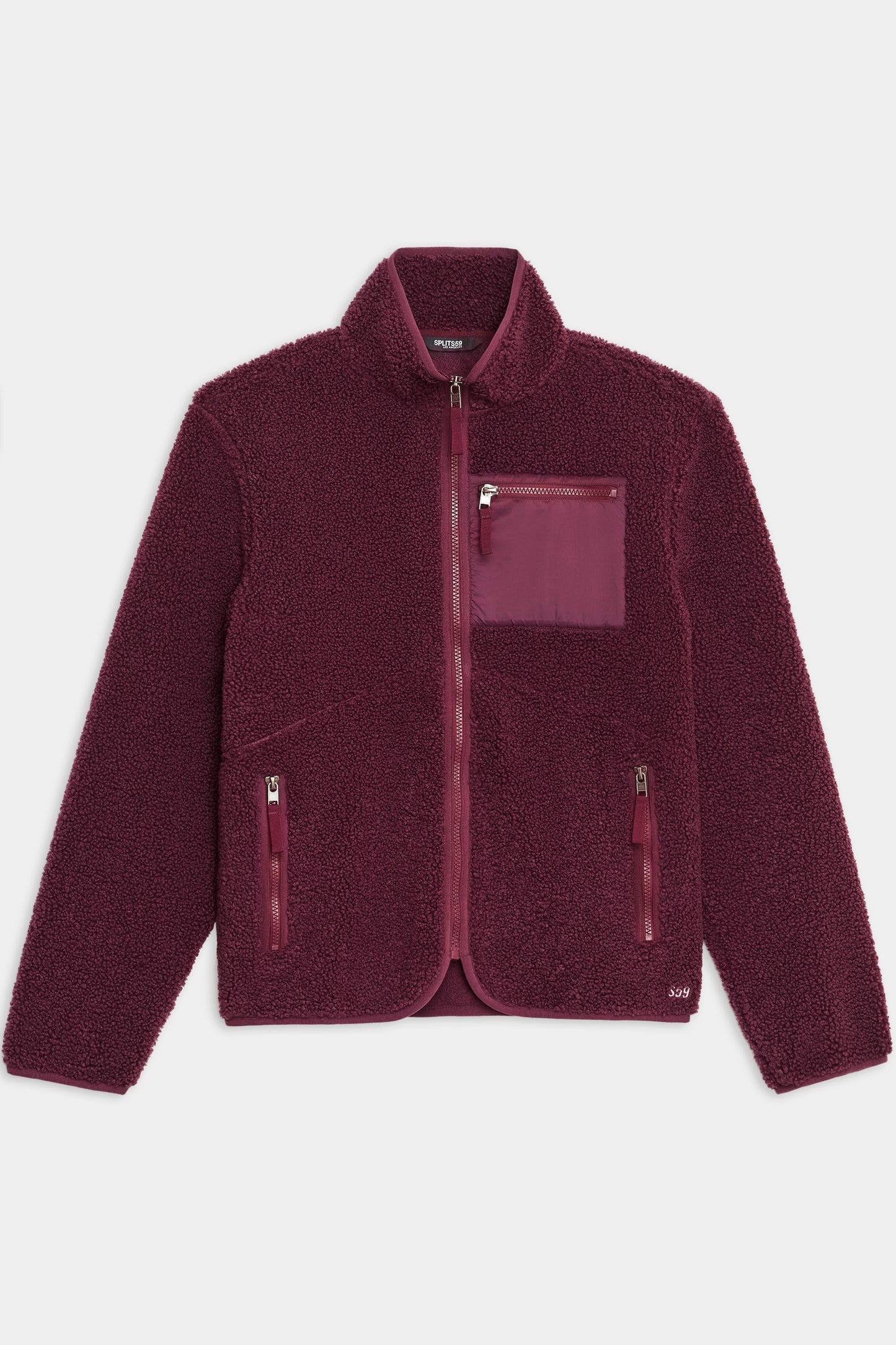 The SPLITS59 Harris Sherpa Jacket in Dark Cherry, made of soft polyester, features a high collar, front zipper closure, and three zippered pockets. The jacket is shown laid flat on a white background.