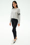 A woman in the SPLITS59 Brooks Stripe Fleece Sweatshirt in Heather Grey/Black and black leggings, crafted from drape-stretch modal fabric and made in Los Angeles.