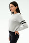 A woman in profile wears the SPLITS59 Brooks Stripe Fleece Sweatshirt in Heather Grey/Black with two black sleeve stripes and black leggings, crafted from drape-stretch modal, standing against a plain background.