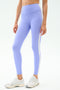 A person wears SPLITS59 Clare High Waist Rigor 7/8 leggings in Purple Haze/White with white athletic shoes, ideal for gym workouts, standing against a plain background.