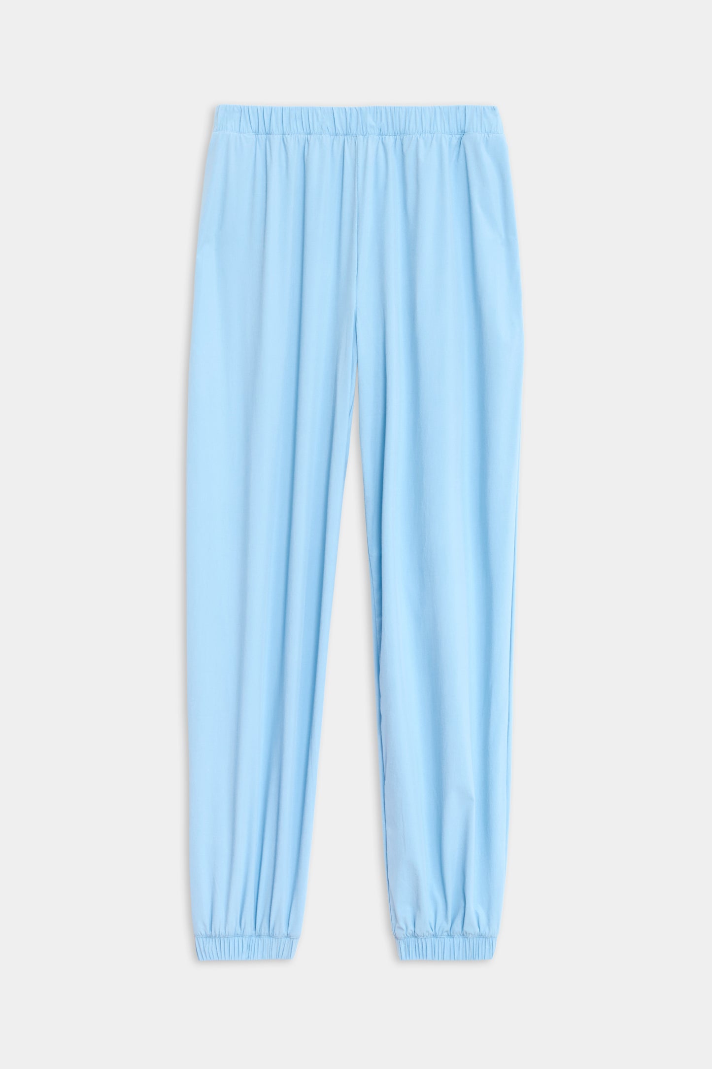 The SPLITS59 Megan Woven Nylon Jogger in light blue features an elastic waistband and cuffs, showcased on a plain white background.
