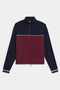 The SPLITS59 Millie Airweight Half Zip is a long-sleeve pullover featuring a navy top, burgundy bottom, white stripe, quarter zip, and zippered side pockets, shown on a white background.