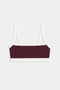 The SPLITS59 Monah Rigor Bra is a sleeveless crop top featuring a dark purple front panel with white straps, hem, and trim, shown on a plain white background.
