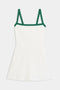The Monah Rigor Dress by SPLITS59 in white/arugula showcases the iconic Monah silhouette with green shoulder straps and trim, set against a plain background.
