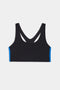 The SPLITS59 Ella Airweight Bra in Black/Classic Blue features a racerback design and blue side panels, made from stretchy nylon spandex, shown against a white background.