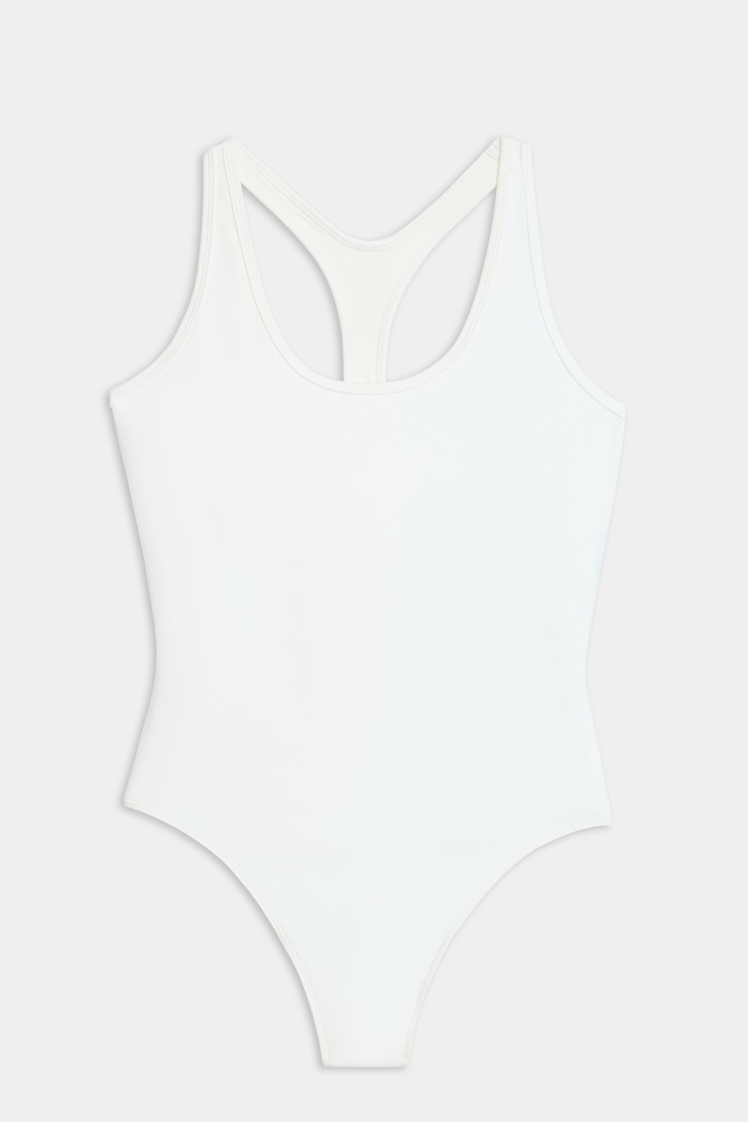 The SPLITS59 Suki Airweight Bodysuit in white is a soft nylon-spandex one-piece with a racerback design, shown on a flat white background.