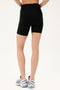 Back view of model wearing black high waist bike shorts paired with white shoes with black stripes