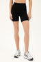 Front view of model wearing black high waist bike shorts paired with white shoes with black stripes