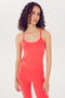 Woman in red nylon-spandex SPLITS59 activewear standing against white background.