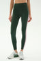 A person in SPLITS59 Margot Rigor Legging - Military/Blush stands against a plain white background, paired with gray New Balance sneakers.