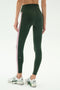 A person wearing SPLITS59 Margot Rigor Legging in Military/Blush with white athletic shoes, standing against a plain light background.