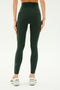 A person is standing with their back to the camera, wearing SPLITS59's dark green Airweight Super High Waist 7/8 - Military leggings made of ultra luxe fabric and white sneakers against a plain background.