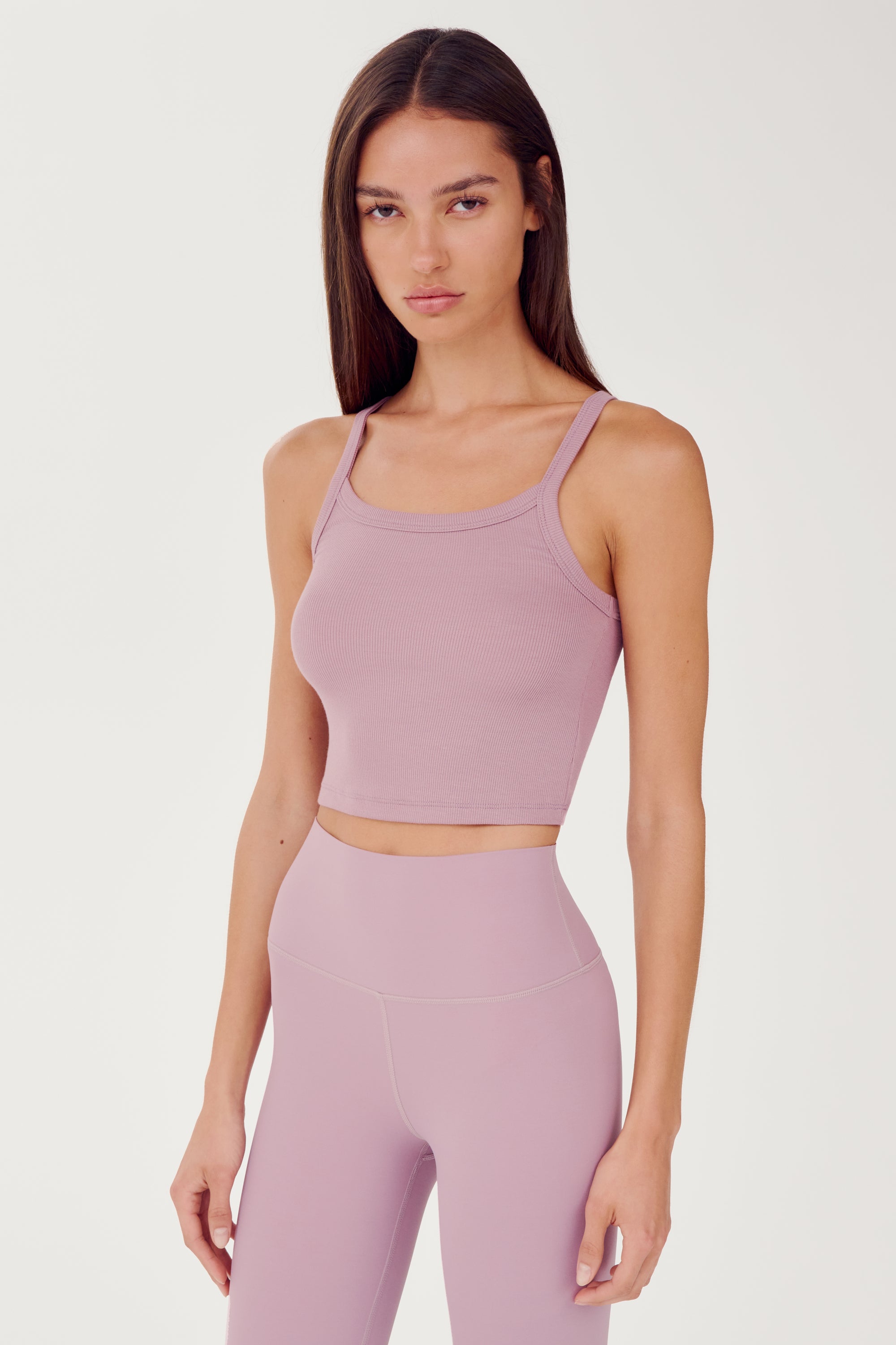 Side view of girl wearing light pink ribbed square neck cropped tank top with light pink leggings