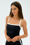 A person is wearing the SPLITS59 Monah Rigor Tank in black with white straps, standing against a plain background.