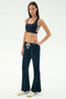 A woman wears the SPLITS59 Blaire Rib Pant in Indigo, made from soft modal and spandex, paired with a matching sports bra and white sneakers, posing against a plain white background.