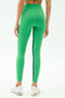 Wearing SPLITS59 Easton Rigor High Waist 7/8 leggings in Grass/White, a person is shown from the back in green leggings with black seam detail and white sneakers. The compressive fabric offers support for any fitness routine.