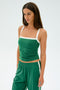 A person with long hair models the Monah Rigor Tank in Arugula/White by SPLITS59, paired with matching spandex pants, set against a plain background.