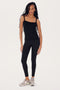 Young woman in SPLITS59's Romy Rib Tank - Black and leggings standing in a neutral pose against a white background.